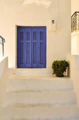 Island white architecture with blue window and plant. Minimal composition. Summer inspiration.