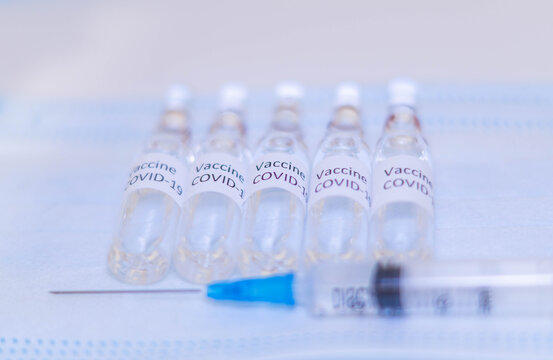 ampoules with Covid-19 vaccine on a laboratory on the table, syringe