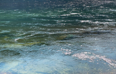 Obraz premium Blue abstract moving water background with sun sparkles