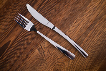 set of knives, spoons and forks on wooden background