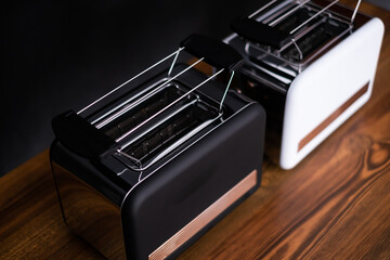 Toaster on wooden table against black background, space for text