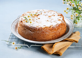 Healthy Wholemeal apple cinnamon tea cake on light blue background with copy space. Homemade baked concept. Mother's Day, Birthday Cake card Background. Spring time.
