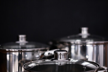 Set of grill pans on wooden table against black background, space for text