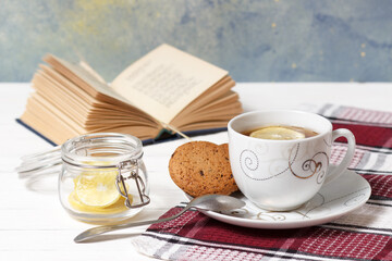Still life with a cup of black tea with lemon and a book of poems in the background.