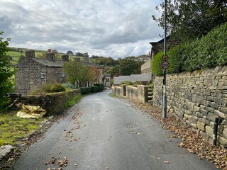 View down, Back Leeming road, on a rainy day, with cottages, fields, and heavy clouds in, Oxenhope, Keighley, UK