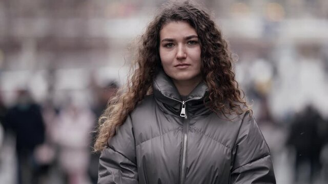 pretty smiling woman on street of big city at winter day, slow motion portrait shot, townswoman