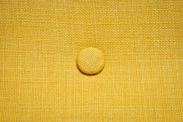 Home upholstered furniture concept. Yellow fabric background. Three round ornament detail.