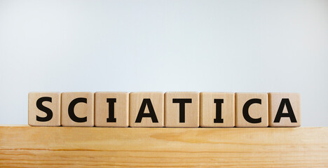 Sciatica symbol. Wooden cubes with word 'sciatica'. Beautiful white background. Medical and...