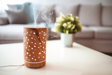 Aroma lamp on table. Aroma oil diffuser on table at home. Air freshener. Aroma health essence, welness aromatherapy home spa fragrance tranquil theraphy.