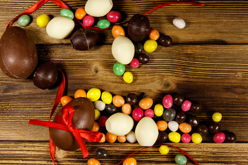 Easter composition with chocolate eggs on wooden background