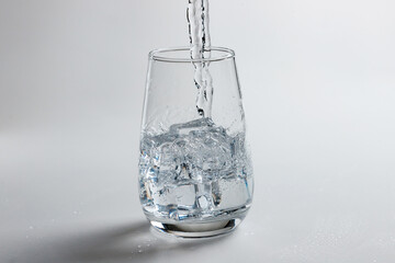 clean water is poured into a glass cup. ice in a glass.