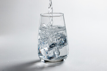 clean water is poured into a glass cup. ice in a glass.