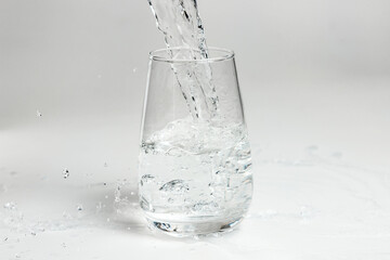 clean water is poured into a glass cup.