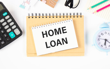 Home Loan text on document with glasses, calculator and office items on the table.