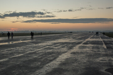 People walking in the former Berlin airport Flughafen Tempelhof now Tempelhofer Feld at sunset in Winter.