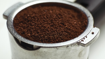 Portafilter with ground coffee. Coffee filter holder. Macro, close-up