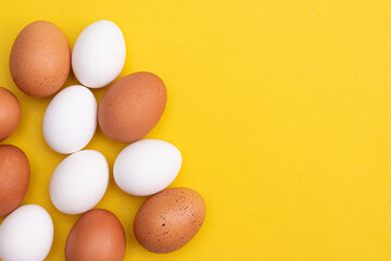 Chicken eggs on a yellow background. Chicken eggs. Article about eggs benefits and harms. Copy space. Yellow background. Food products.