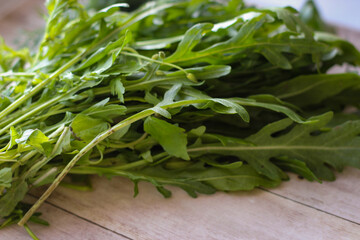 Green dill leaves and arugula on a wooden background