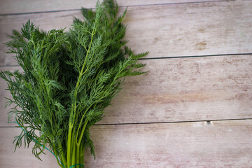 Green dill leaves on a wooden background