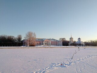 A walk in an open forest park Kuskovo in winter near the palace pond, snow around, Morning blue sky