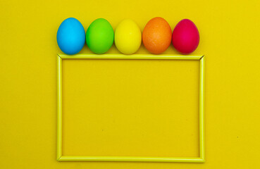 Painted eggs on a yellow background. Chicken eggs on a yellow background in a frame. Space for the text. Chicken eggs are colored. Easter. Orthodox holiday. An article about Easter. Article about eggs
