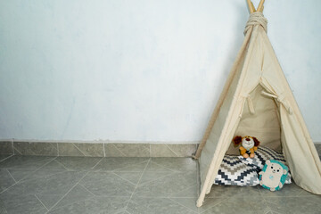 White room with teepee and baby's toys