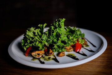 Delicious autumn mushroom salad with grilled mushrooms, tomato, fresh lettuce and rocket served in a bowl with toasted baguette