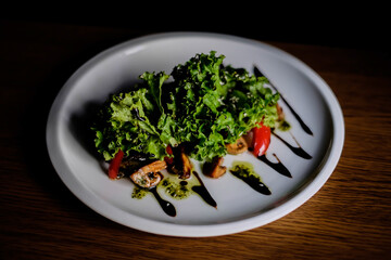 Delicious autumn mushroom salad with grilled mushrooms, tomato, fresh lettuce and rocket served in a bowl with toasted baguette