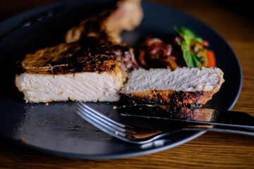 grilled steak on the bone on a blue plate on a wooden table