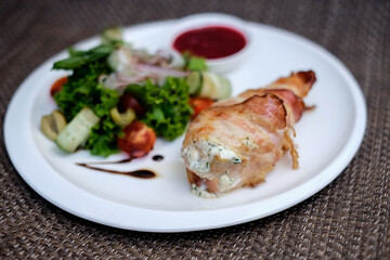 Chicken breast stuffed with cheese sauce and wrapped in pancetta bacon.