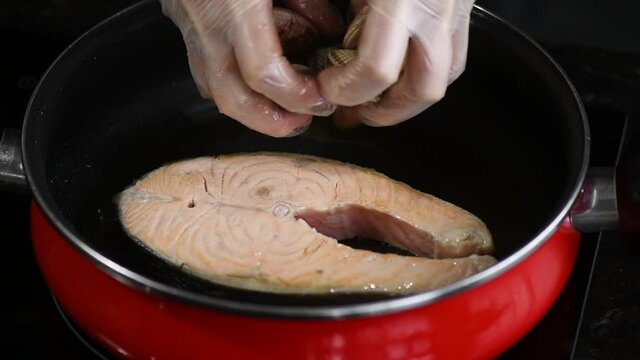preparing salmon casserole, releasing the cockles with your hand and gloves