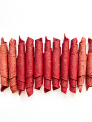 Red fruit leather rolls isolated on white. Fruit candy - pastille. Top view.