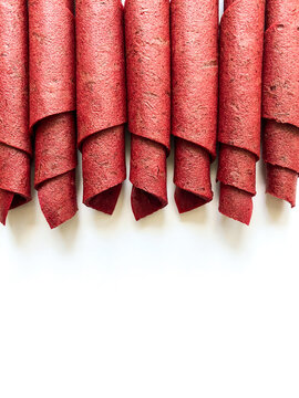 Red fruit leather rolls isolated on white. Fruit candy - pastille. Top view.