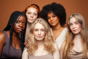 Fototapeta premium young pretty caucasian, afro, scandinavian woman posing cheerful together on brown background, lifestyle diverse nationality people concept
