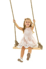 Beautiful girl swinging on wooden swing