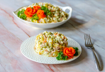 Traditional Russian festive salad Olivier (winter salad) on a white plate.	