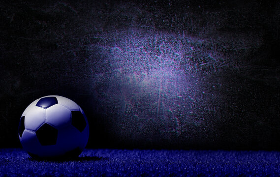 Soccer football ball on grass over dark background. Blue color filter