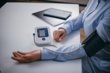 Hands with a tonometer on the table