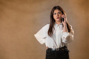 joven guapa y atractiva hablando y respondiendo whataspp y sms con el movil en la mano y camisa...