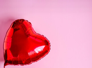 Red heart balloon on a pink background.