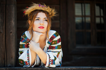 Beautiful young woman posing in romanian traditional costume.