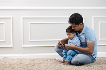 parent and child looking at cellphone at the living room 