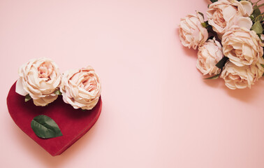 Fall in love at first sight. Heart and bouquet of pink roses on pastel pink background. Love concept. Flat lay.	Top view.