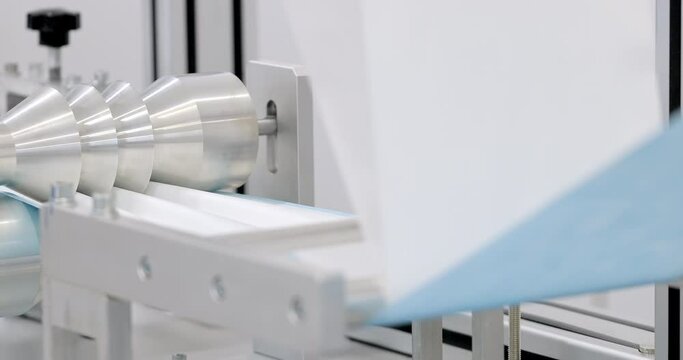 Manufacture of respiratory face masks. The machine makes the crease on the protective material for the face masks. Production of disposable surgical clothing for protection against the virus.