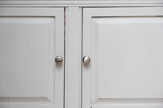 Silver knobs on white cabinet doors on an American Home Kitchen