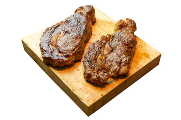 2 prime rib eyes cooked in medium rare on a wooden board white background