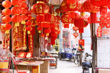 Chinese new year red lanterns and spring couplets sold in shop, Spring Festival decorations hung on the arcade of Dongguan, China.