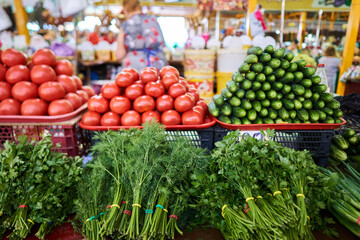 Vegetables on market stall. Tomato, cucumber, parsley, dill on bazaar market