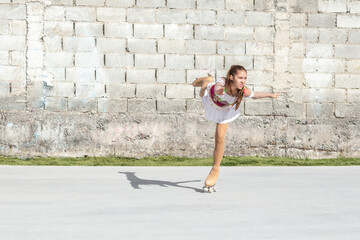 Teenage girl doing a figure roller figure skating figure skating spinning on one leg while © FABIAN PONCE GARCIA