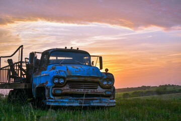 An old chevy truck in front of a colorful sunset